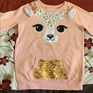 A sweater that has a reindeer on it